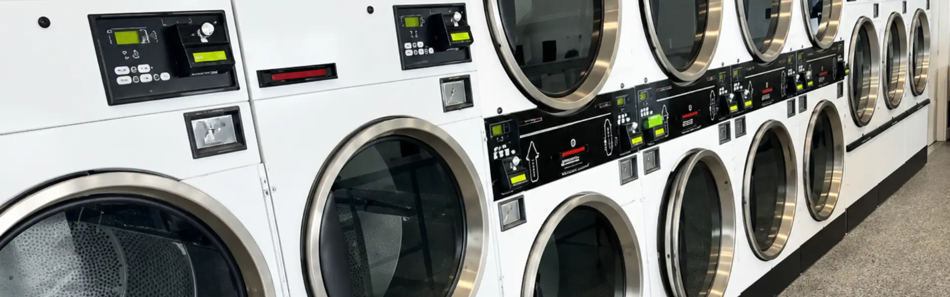 close up of multiple laundry machines inside spin and spray laundromat
