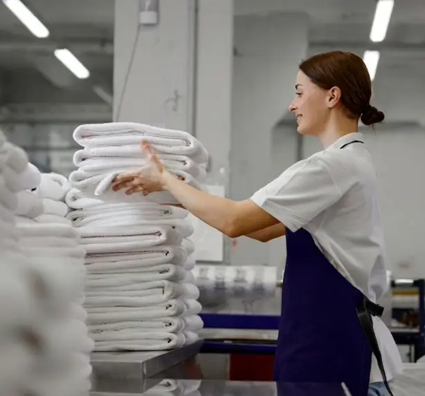 laundry worker stacking folded towels